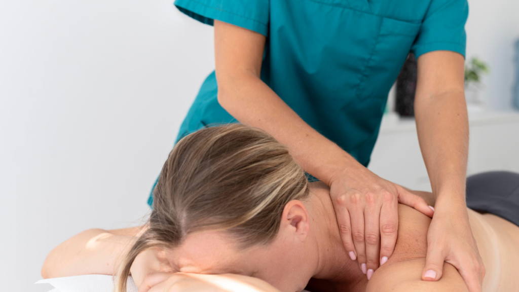 Massage therapist performing shoulder and neck treatment in a professional massage therapy clinic in Riverbend Edmonton