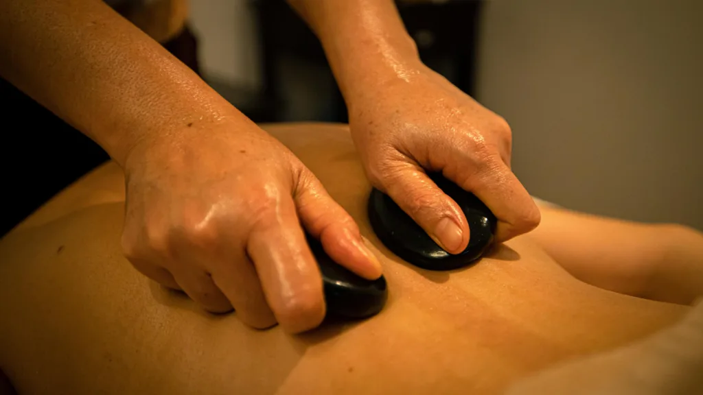 Hot stone massage in Edmonton using heated stones for muscle relaxation