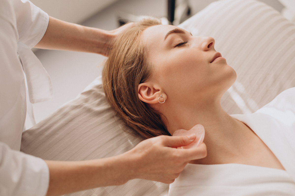 Therapist performing facial lymphatic drainage on relaxed client in Edmonton