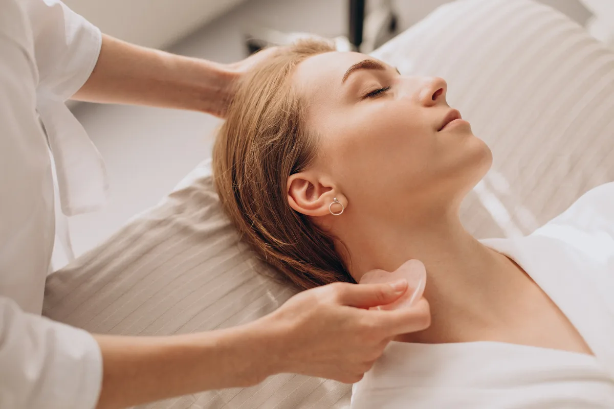 Therapist performing facial lymphatic drainage on relaxed client in Edmonton