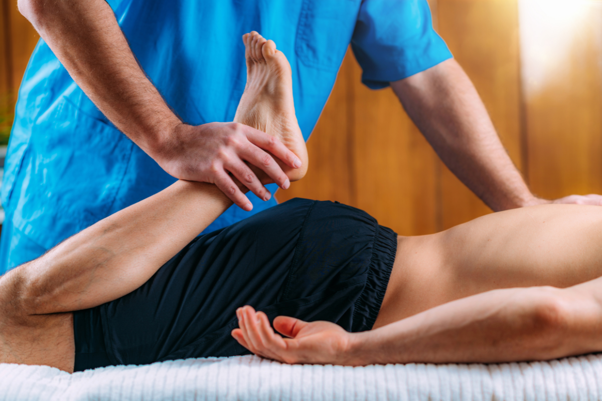 Sports massage therapist working on client's leg in Edmonton