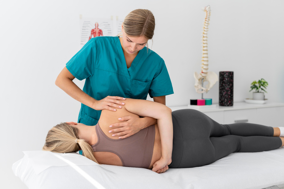 Registered massage therapist treating female athlete back during sports massage session at Edmonton clinic