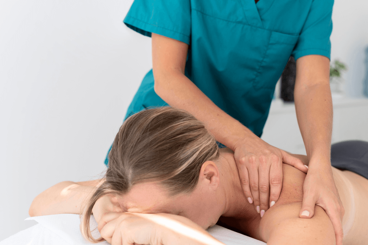 Registered massage therapist treating client neck and shoulders during massage therapy session in Edmonton